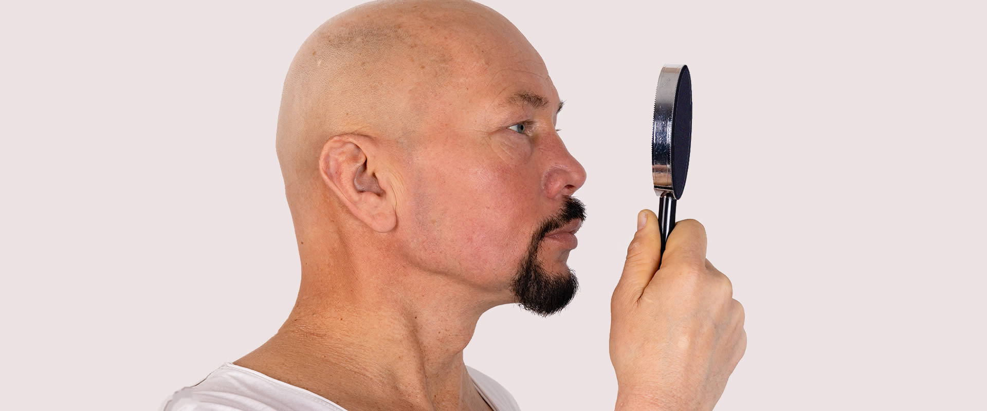 Man looking at his Artificial Eye in a Mirror