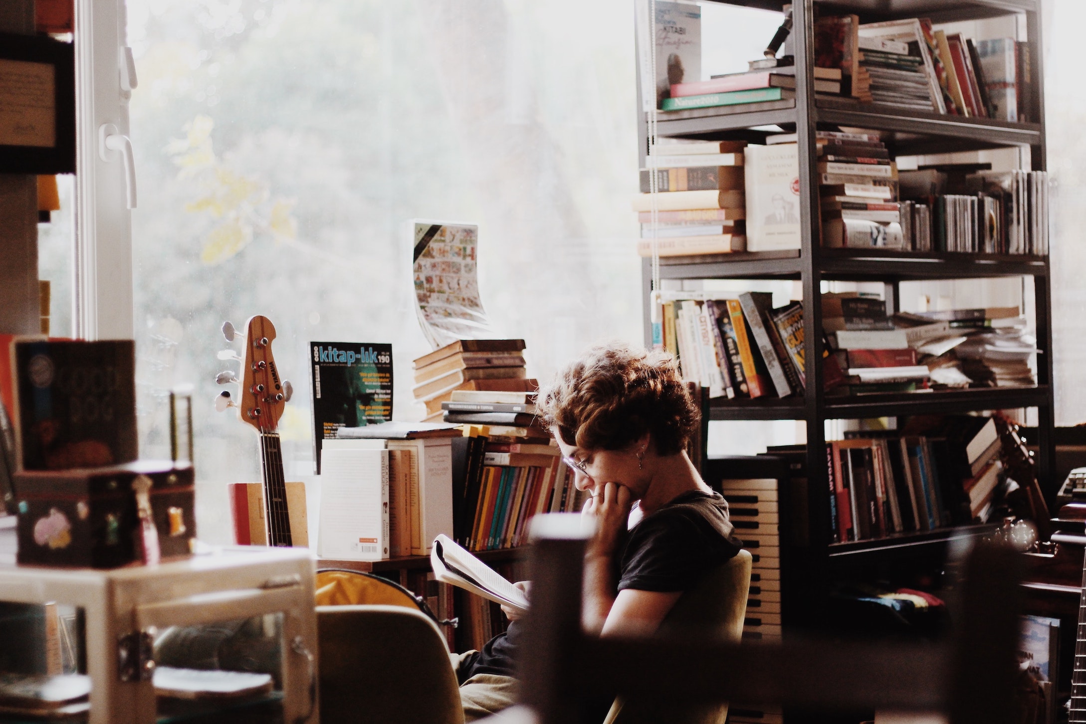person surrounded by musical instruments and music books