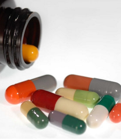 Medical pills spilling out from brown bottle