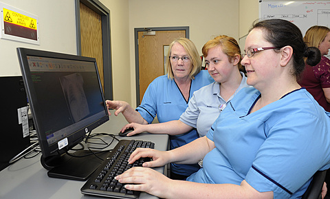 Three women working together on a computer