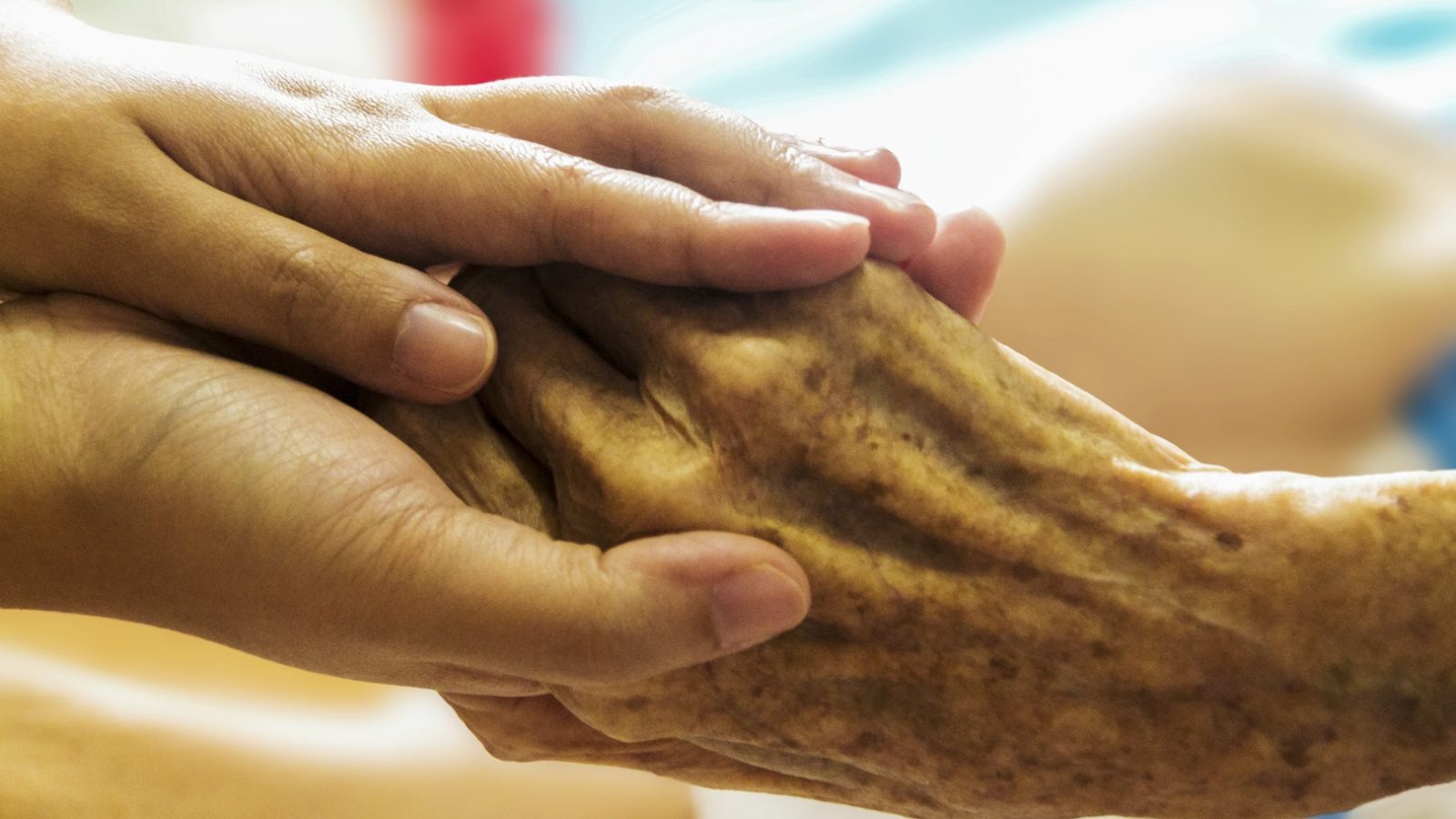 Clasped hands of an older person and a younger person