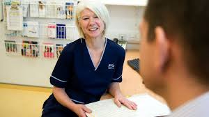 Nurse standing at desk with notes.