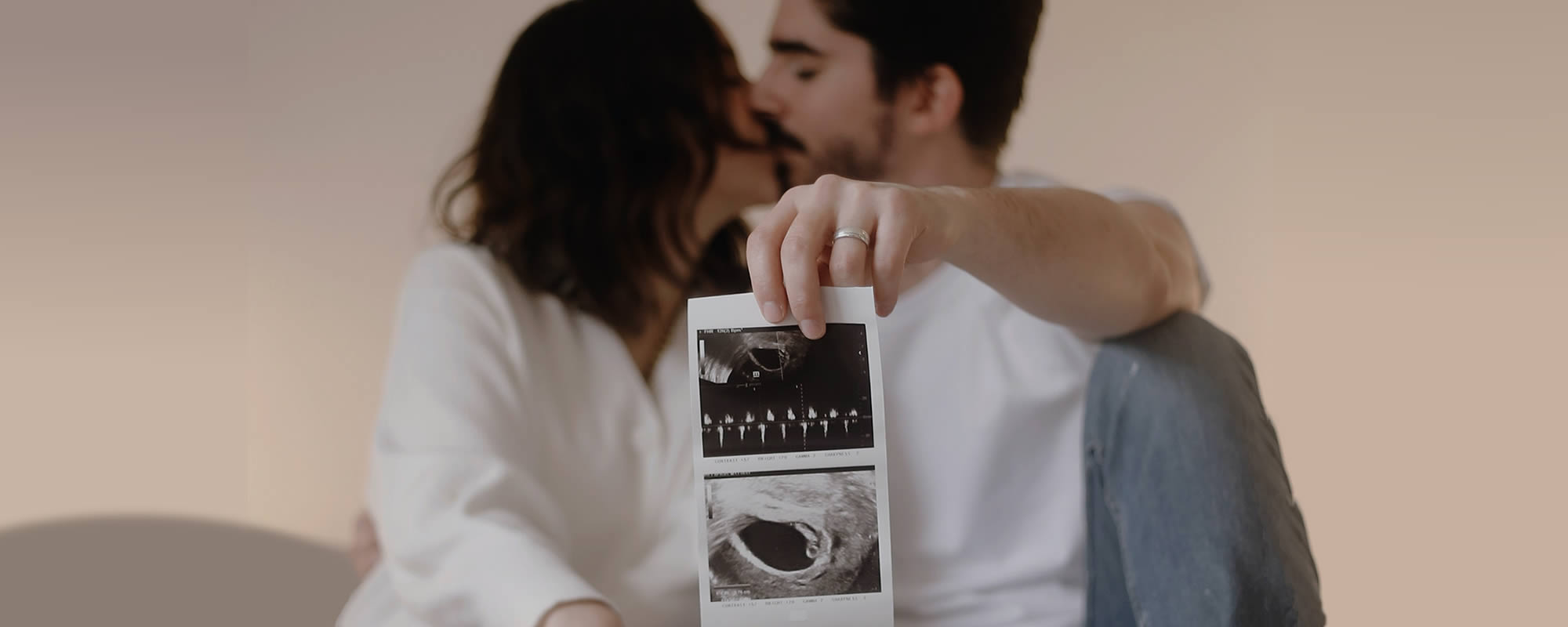 Loving Couple holding Baby Scan Photographs