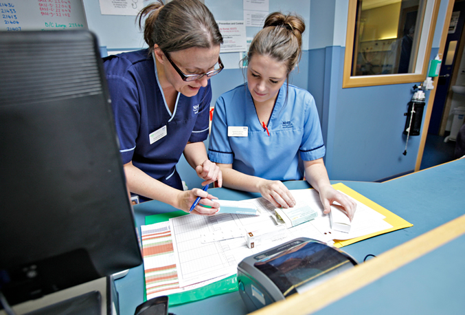 Two nurses looking at medical records