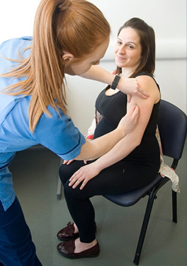 Pregnant woman having vaccine injection