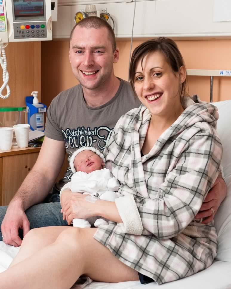 A young couple with their new baby on the ward