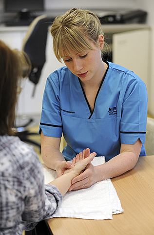 Physiotherapist attending to patients wrist and hand