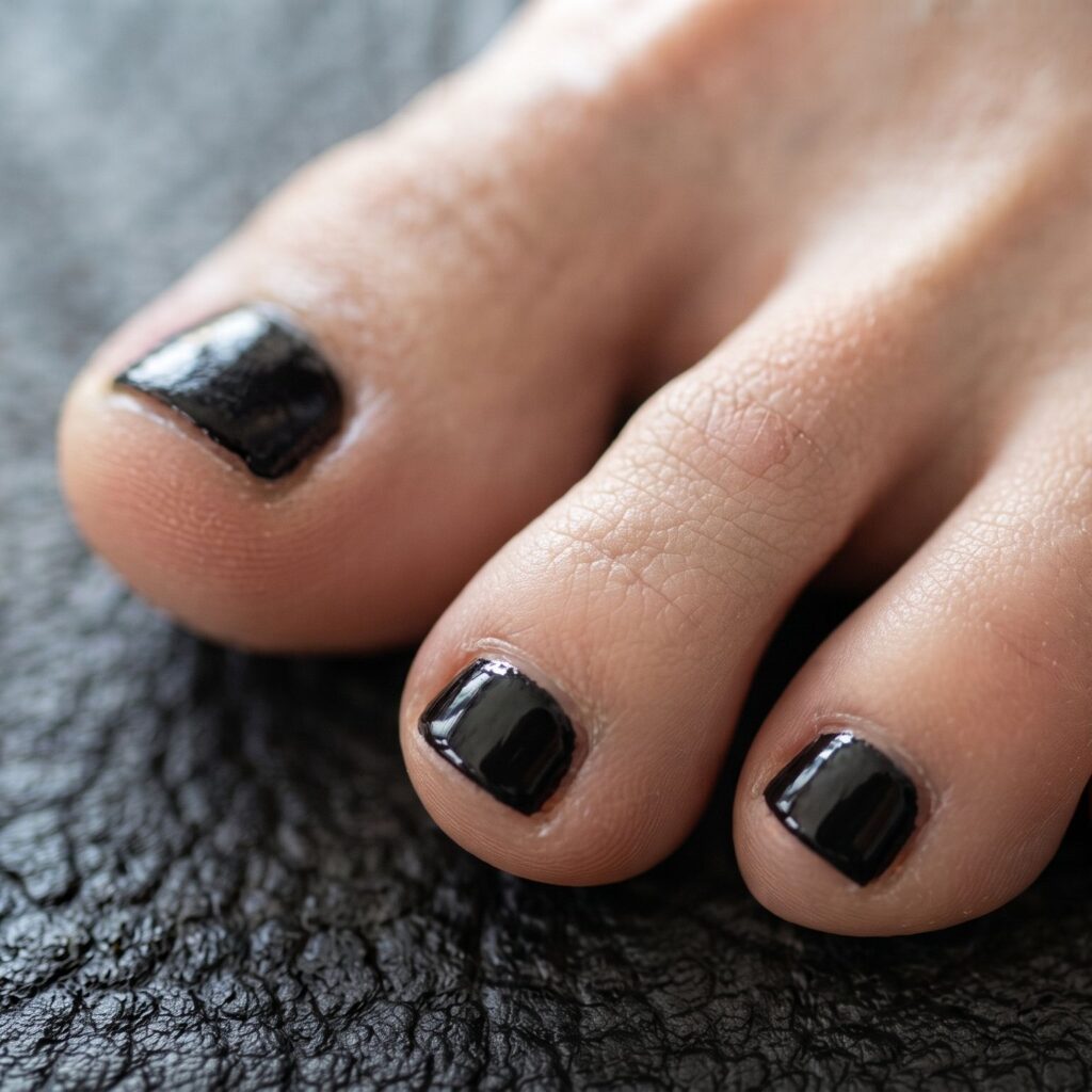 Close up of three toes with black nail polish