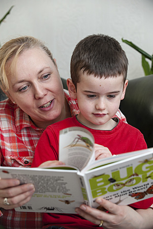 Mum reading a book with her son.