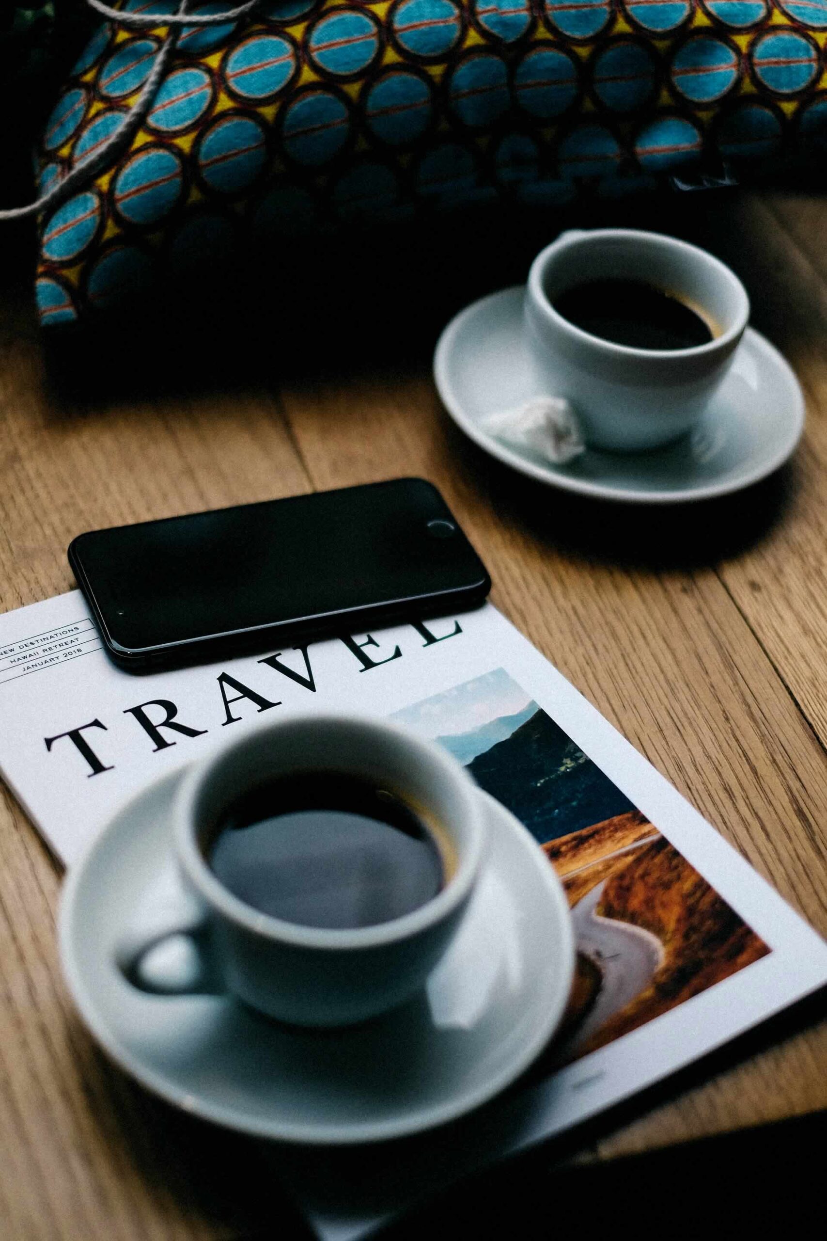 Travel Magazine with Cups of Coffee and a Mobile Phone