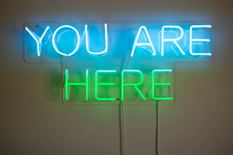 A neon sign reading, you are here