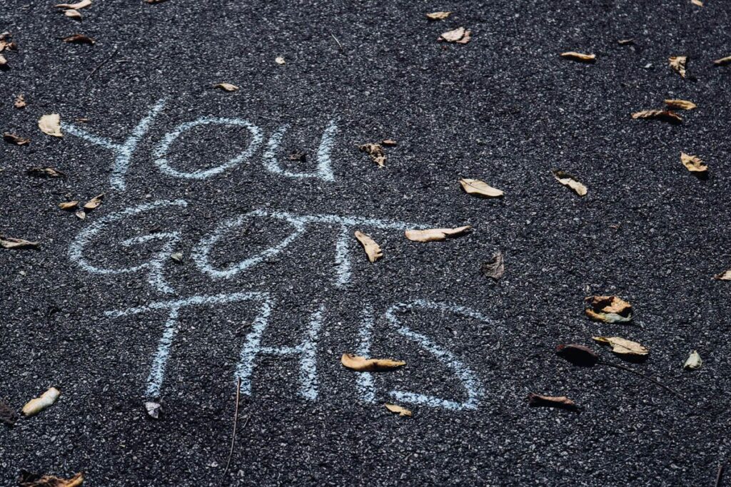 Chalk message on tarmac reading: You Got This