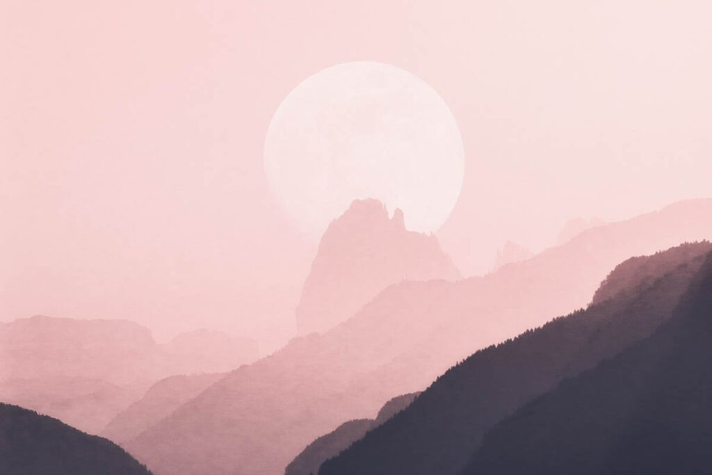 Pink sky with sun over mountains