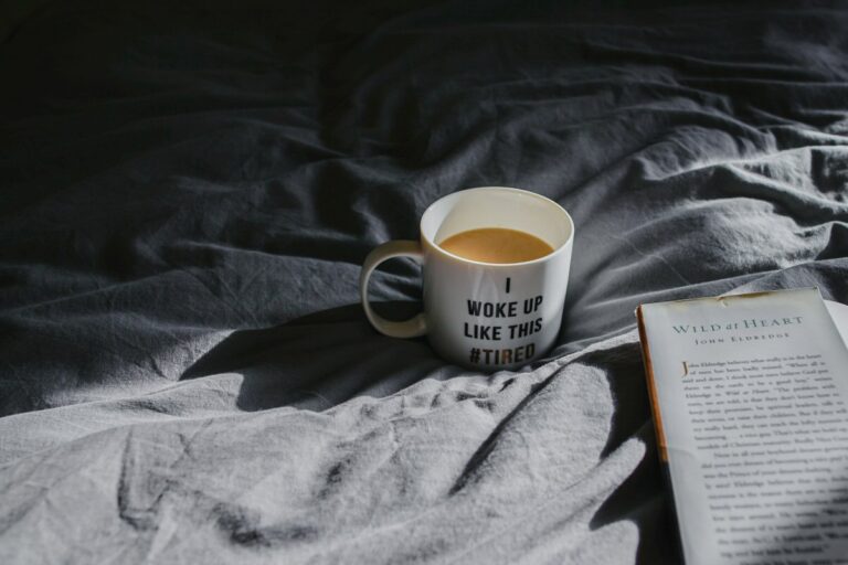 A cup of tea, and a book, on a recently vacated bed